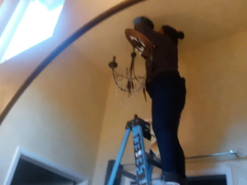 Electrician installing a chandelier in a Dublin residence